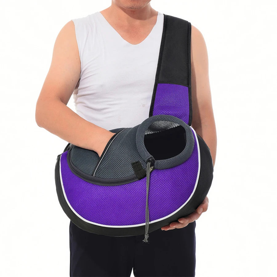 Person holding a purple and black pet carrier on a white background