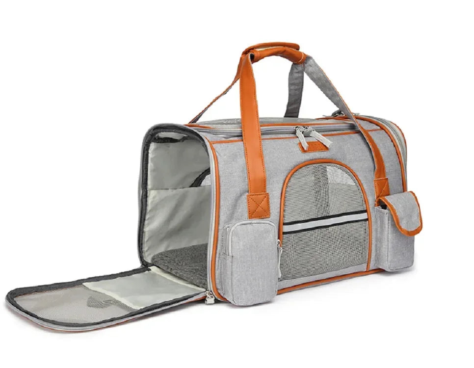 Gray pet carrier with orange handles and trim on a white background